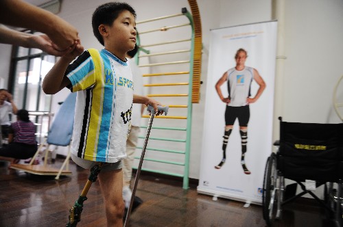 160; 北川县曲山小学学生邱耀装着假肢围着健身房练习行走(7月14日摄)