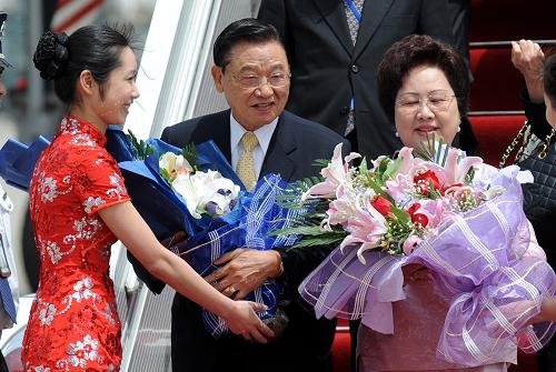 4月25日,礼仪小姐在飞机舷梯下向江丙坤及夫人献花.