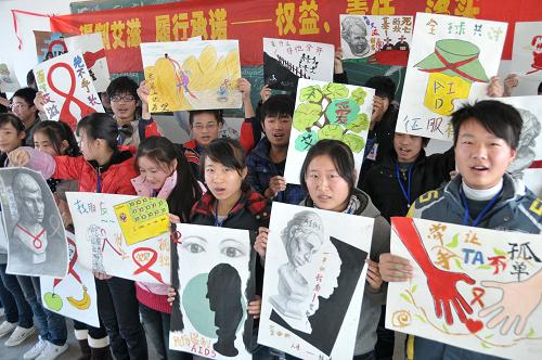 安徽省含山县职教中心学生正在展示他们创作的预防艾滋病创意宣传画