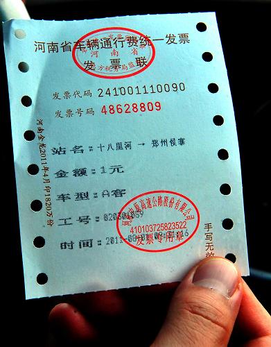 一名司机展示一张由郑州绕城高速公路侯寨收费站开具的收费发票