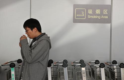 5月1日,乘客在首都机场t2航站楼吸烟区吸烟.新华社发(万象 摄)
