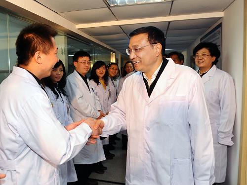 1月19日,中共中央政治局常委、国务院副总理李克强来到国家人口计生委及所属研究机构,考察人口计生科研、管理和服务工作。这是李克强在国家人口计生委科研所与研究人员亲切握手。新华社记者 李涛 摄