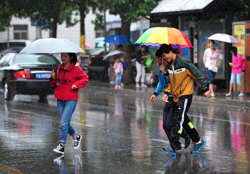     7月22日,在宁夏银川街头,市民在雨中前行.