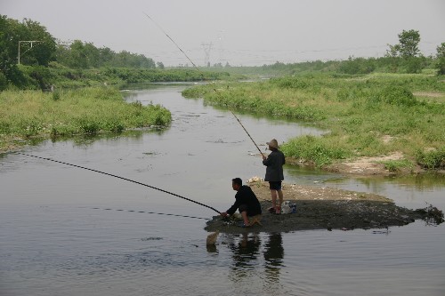两位垂钓爱好者在涝河边钓鱼