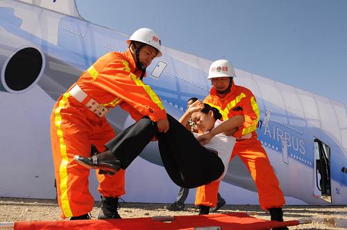 员被救援人员抬下飞机。 新华社记者 周文杰