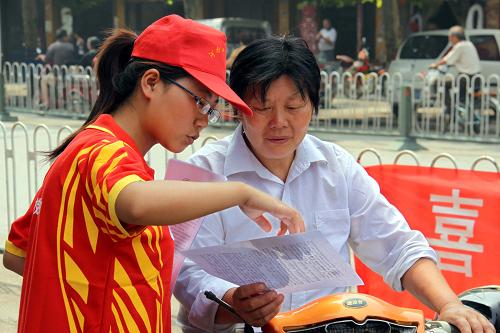 7月15日,在河南省博爱县中山路,河南工业大学经贸学院的学生向行人宣传预防甲型H1N1流感常识。这次宣传是这些学生“关注山区民生,助推农村发展”暑期实践活动中的一项。他们还将举行为山区孩子捐赠学习用品等多项社会实践活动。新华社发(程全 摄)