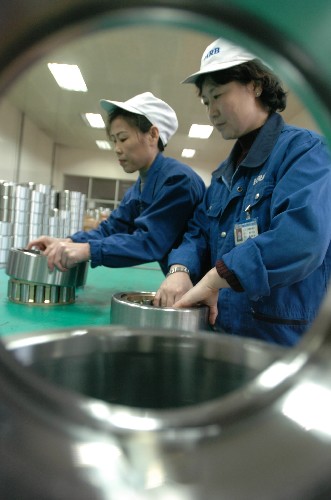 轴承集团公司铁路提速客车轴承生产线上,工人在组装产品(2005高清图片