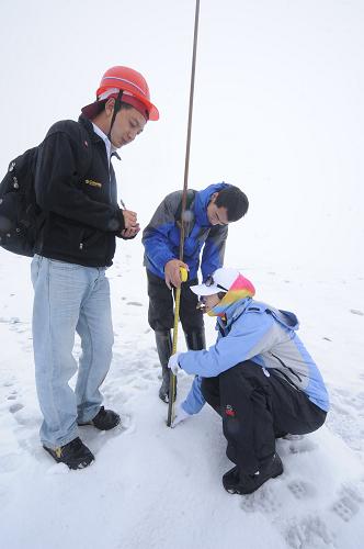 8月22日,中科院丽江玉龙雪山冰川与环境观测站工作人员在海拔4800多米的地点测量花杆变化。新华社记者 秦晴 摄