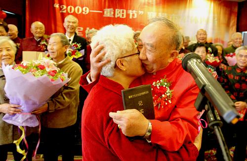 10月26日,一对老人在金婚庆典上相拥相吻。 当日是重阳节,在襄樊市举行的一场金婚庆典活动中,32对金婚夫妇在浪漫悠扬的婚礼进行曲中,共同见证50年的不老誓言和爱情之约。 新华社发(刘涛 摄)