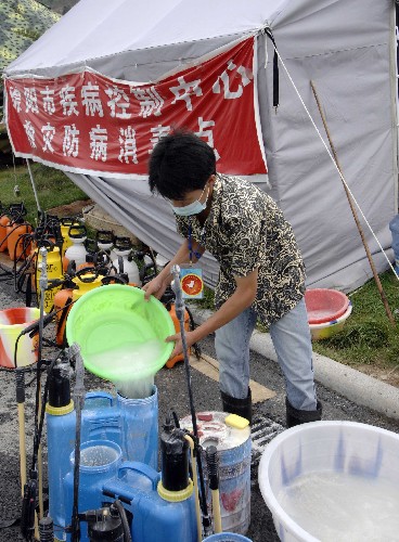 绵阳九洲体育馆:最后的防疫消毒 6月29日,消毒人员在绵阳九洲体育馆外配置消毒液。当日,随着最后1400余名受灾群众撤离绵阳九洲体育馆,九洲体育馆临时安置的使命完成。绵阳市疾控中心、海军总医院的消毒人员和志愿者随即对九洲体育馆内外进行了全面的清理和消毒。 新华社记者章磊摄