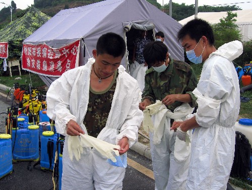 6月29日,消毒人员在绵阳九洲体育馆外穿专用防护服。
