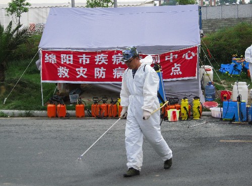 6月29日,海军总医院的消毒人员在对绵阳九洲体育馆馆外道路进行消毒。
