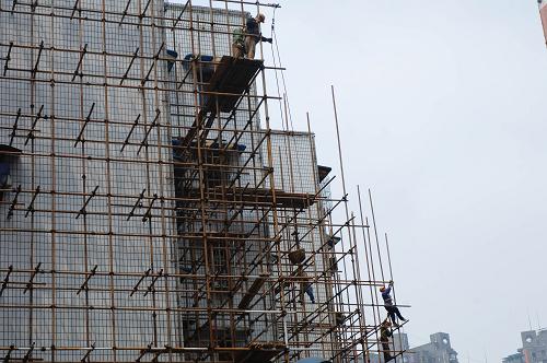 5月18日,施工人员在搭建脚手架,为外墙"洗脸