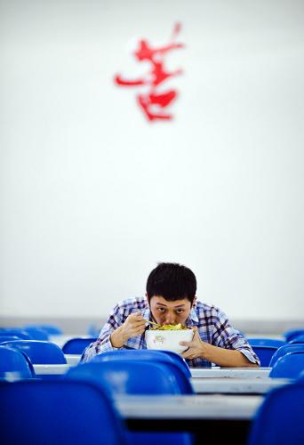 5月24日,在长沙达材复读学校内,学生石柯在吃