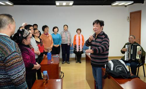 12月25日,盲人文化志愿者、男高音歌唱家富立明(右二)和空政文工团国家一级演奏员任士荣(右一)在盲文图书馆辅导盲人歌唱发声。新华社记者 李鑫 摄
