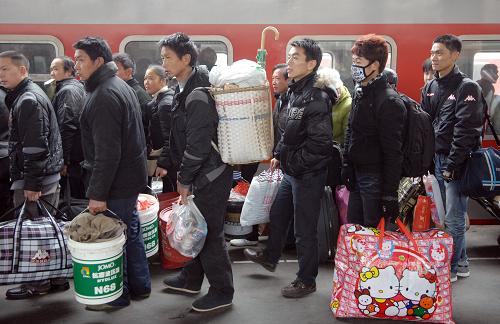1月18日,许多回家的旅客背着背包在站台上候车。 当日是全国铁路春运启动的前一天,众多外来务工人员背起沉重的行囊,满载着一年的收获,来到杭州火车站踏上回乡之旅。据介绍,今年春运浙江地区预计发送旅客1010.2万人次,同比增长14.1%。 新华社记者 鞠焕宗 摄