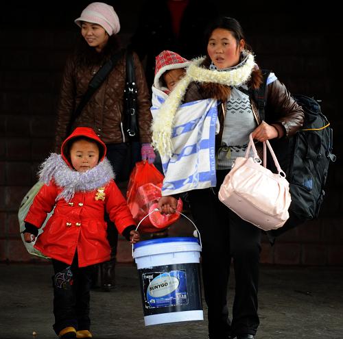 1月18日,一名妇女带着孩子背着行李,准备乘坐杭州开往成都的k1271次列车。 当日是全国铁路春运启动的前一天,众多外来务工人员背起沉重的行囊,满载着一年的收获,来到杭州火车站踏上回乡之旅。据介绍,今年春运浙江地区预计发送旅客1010.2万人次,同比增长14.1%。 新华社记者 韩传号 摄