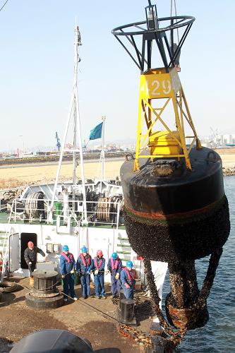 工将夏季航标从海中吊上船。当日,天津海事局