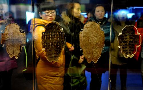 安阳/2月14日，游客在安阳殷墟博物苑甲骨文展览厅参观。