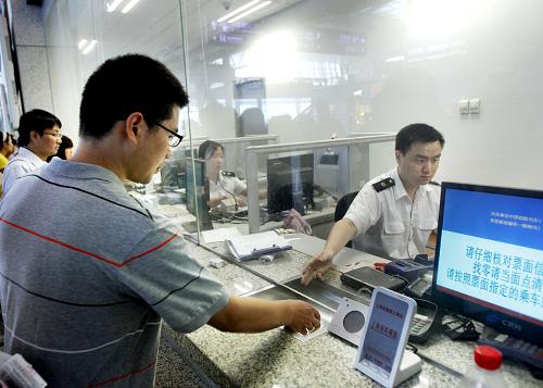 苏力/7月13日，一位旅客正在上海虹桥火车站退票窗口办理退票。新华...