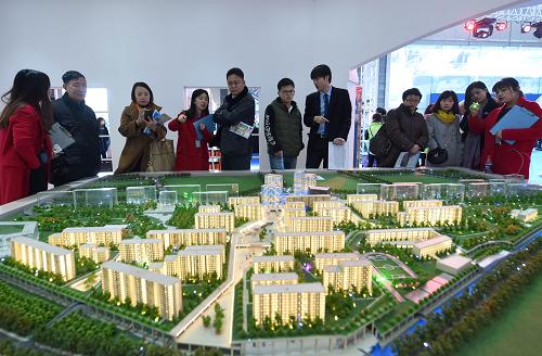 11月27日，观众在房博会上观看房地产开发商推出的楼盘模型。