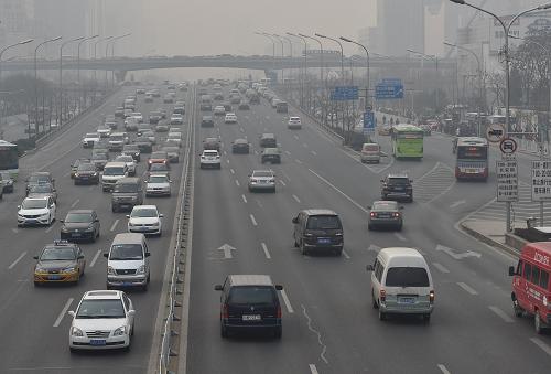 11月28日，汽车在雾霾下的北京国贸桥附近行驶。当日，北京出现重污染天气。