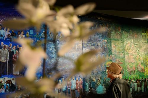 这是2015年4月21日，一名观众在南非约翰内斯堡大学欣赏中国艺术家李斌创作的油画《曼德拉》。新华社记者 翟健岚 摄