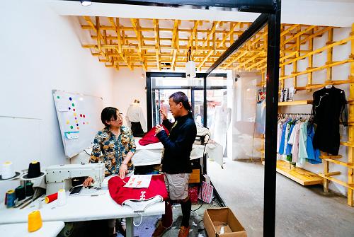 扎西（右）在拉萨的工作室将刚刚绘制好的服装设计草图和布料交给裁缝制作，并叮嘱剪裁注意事项（8月12日摄）。“怡嗡”是一个生根于拉萨的时装品牌，服装设计带有浓浓的藏式风情。它的创办人，是一名年仅32岁的藏族小伙子——根确扎西。根确扎西来自四川甘孜，2006年从烟台师范学院毕业后开始闯荡打拼，2011年来到拉萨。2012年，扎西创立了自己的服装品牌“怡嗡”并举办时装发布会，开始了他在拉萨的创业征途。“怡嗡”的成长之路并非坦途，但扎西从未忘记他的梦想——创造一个时尚品牌，从西藏走向全国乃至世界。而他的坚持也有了收获：“怡嗡”服装目前不仅亮相国内市场，还远销尼泊尔、印度和欧洲。