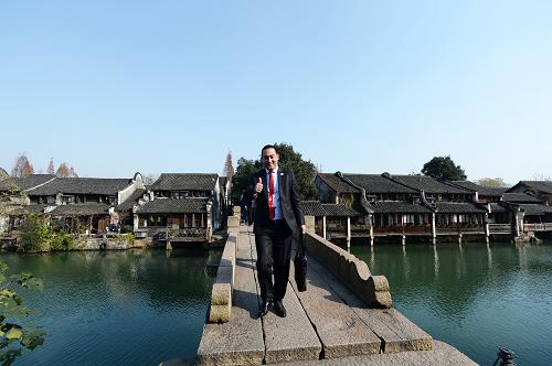 12月16日，外国嘉宾通过浙江乌镇的一座桥准备进入互联网大会会场。新华社记者 黄宗治 摄