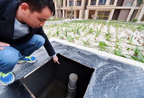 工作人员在翔安区洋唐保障性安居工程介绍雨水花园的地下储水井（12月16日摄）。