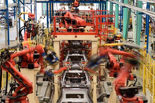 山东威海南海新区德瑞博新能源汽车生产车间的工业机器人在进行焊接作业（11月14日摄）。