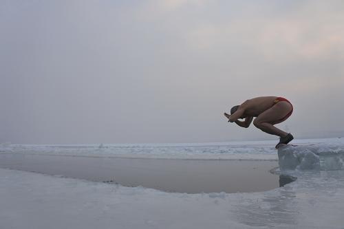 12月22日，农历冬至，黑龙江省牡丹江市一名冬泳爱好者飞身跃入冰河。新华社发（张春祥 摄）