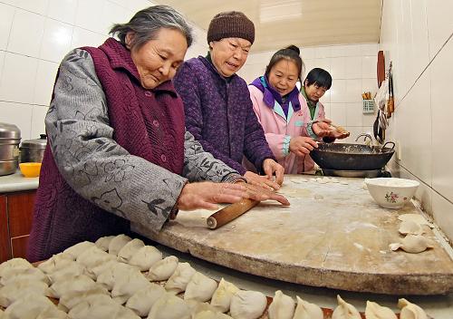12月22日，农历冬至，山东省烟台市向阳敬老院的老人正与护理人员一起包饺子，我国北方有过冬至吃饺子的习俗。新华社发（唐克 摄）