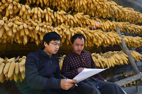 "吴松(左)在李家河回龙村贫困农户乐松清家中商量制定脱贫致"作战图"