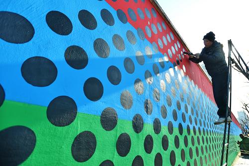 12月22日，上海市虹口区四平街道，白墙被215步长的彩色墙面所代替，艺术家在墙上绘制无数个圆点，经过的车辆可在行进过程中看到动态图像。