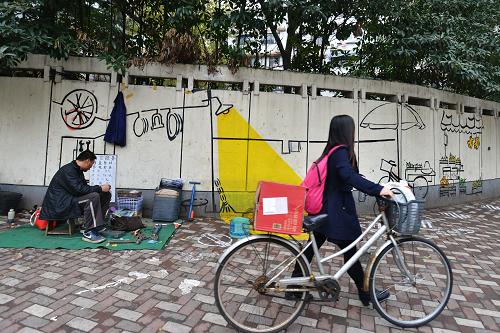 12月22日，上海市虹口区四平街道，艺术家在一个维修自行车摊点的墙面上绘制了涂鸦，增添的有趣的风景线。