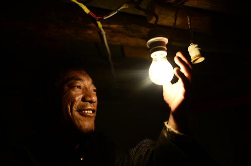 玉树藏族自治州称多县仲达乡歇格村通电后，牧民格来家中使用电灯照明（12月14日摄）。12月24日，记者从国家能源局获悉，随着青海省最后3.98万无电人口实现通电，我国全面解决无电人口用电问题。国家能源局提供的数据显示，2013年到2015年，国家共安排投资247.8亿元，实施无电地区电网延伸和可再生能源供电工程建设，共解决273万无电人口用电问题。新华社记者 张宏祥 摄