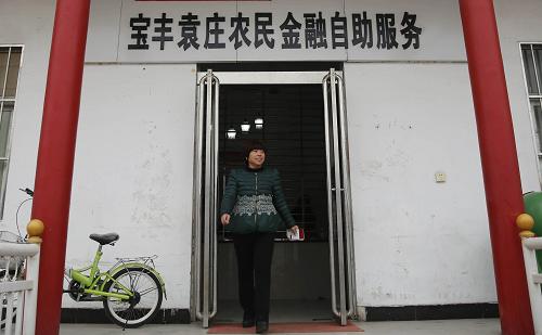 12月27日，村民走出位于河南省宝丰县赵庄镇袁庄村的农民金融自助服务点。
