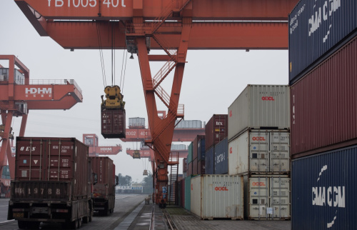 12月30日，工人在宜宾港泊位处装卸集装箱。