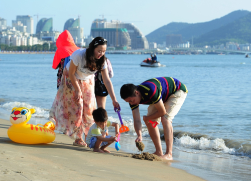 1月1日，游客在海南省三亚市海滩感受暖冬下的椰风海韵。新华社发（沙晓峰 摄）