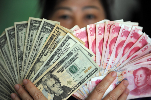 1月7日，海南琼海一位市民在展示人民币和美元。新华社发（蒙钟德 摄