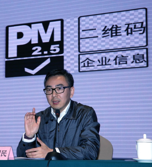 1月18日，中国纺织品商业协会副会长兼秘书长、安全健康防护用品委员会会长雷利民在介绍背后的“PM2.5防护口罩”特定标识。新华社记者 殷刚 摄