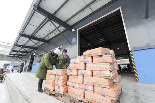 1月19日，滨江物流中心装卸工人将货物运送至仓库。