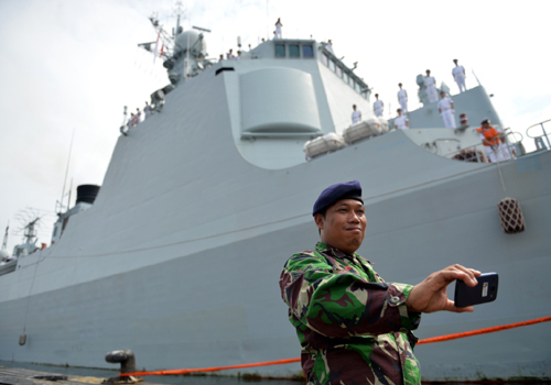 1月24日，在印度尼西亚雅加达港口，一名印度尼西亚军人在来访的中国海军济南舰前拍照留念。新华社记者 贺长山 摄
