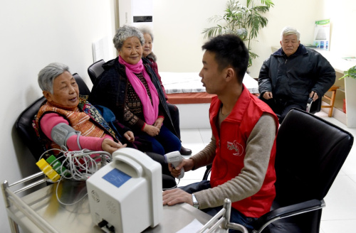 1月28日，洛阳市延安社区智慧养老服务中心的工作人员在为老人测量血压和体温。新华社记者 李安 摄
