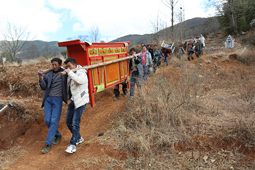 1月28日，会泽县纸厂乡小路沟村民在搬运家具，准备入住新居。