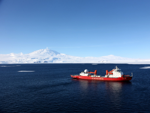 这是2月6日从空中拍摄的停泊于南极罗斯海的“雪龙”号，不远处就是罗斯岛上的埃里伯斯火山。当日，中国极地科考船“雪龙”号抵达南极罗斯海进行科考作业。罗斯海是南太平洋深入南极洲的大海湾，是地球上船舶所能到达的最南部海域之一。新华社记者 朱基钗 摄