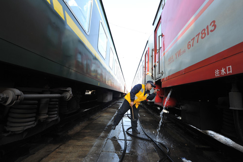 2月7日，成都火车站驻站检车员焦峰利用列车停靠车站的短暂时间查看列车状况。