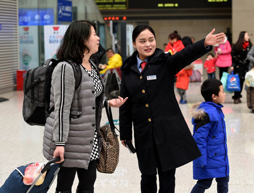 2月7日，郑州东站的工作人员指引旅客进站乘车。