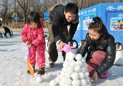 2月9日，在北京陶然亭公园，3岁多的谷思娴小朋友与爸爸妈妈一起堆雪球、搭雪屋。新华社记者 陈海通 摄